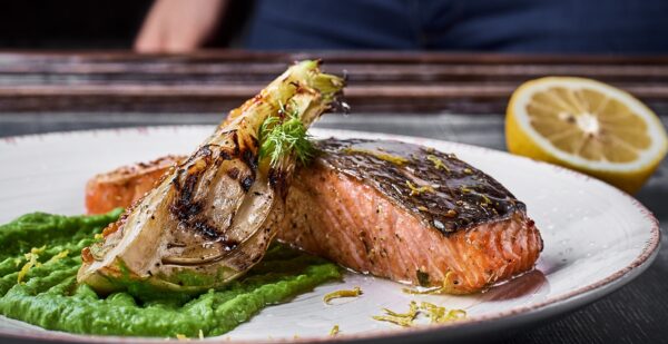 hand-squeezes-lemon-baked-salmon-steak-with-mashed-green-peas-caramelized-onions FRAWNS 65