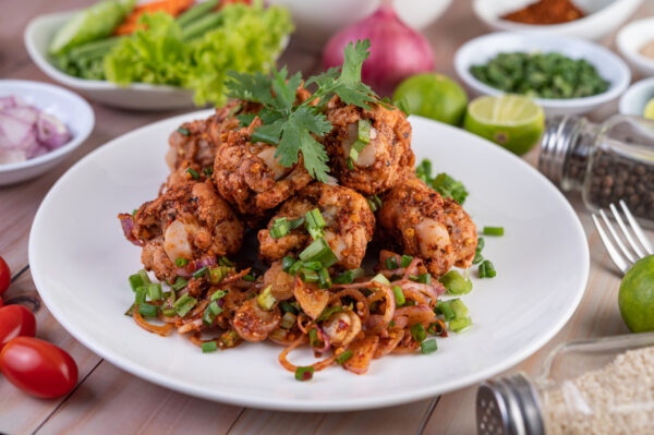 Spicy minced chicken on a white plate complete with cucumber, le PEPPER CHICKEN